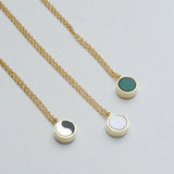 Three gold toned necklaces with chrysoprase, mother of pearl, and ying yang shown on a white background