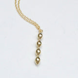 Simple geometric bubble charm on a delicate chain in bronze