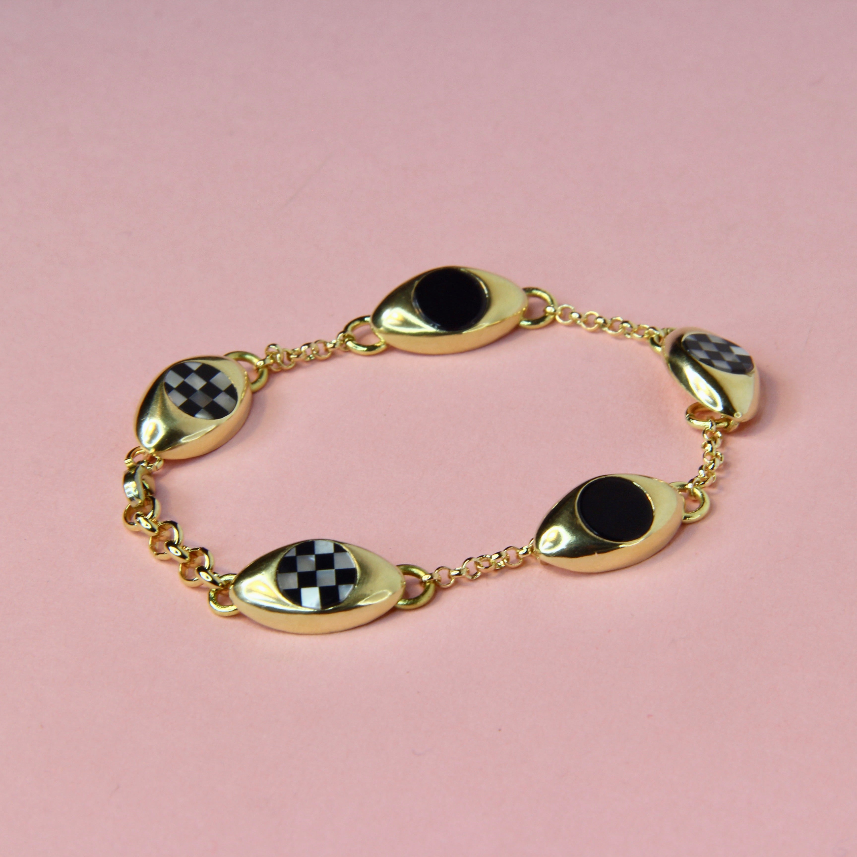 Bronze gold toned bracelet with five oval charms and black onyx and checkerboard inlay stones