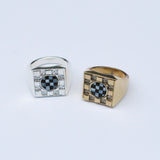 Two square signet rings with a metal checkerboard pattern - one silver and one bronze - and checkerboard stone inlays in the center