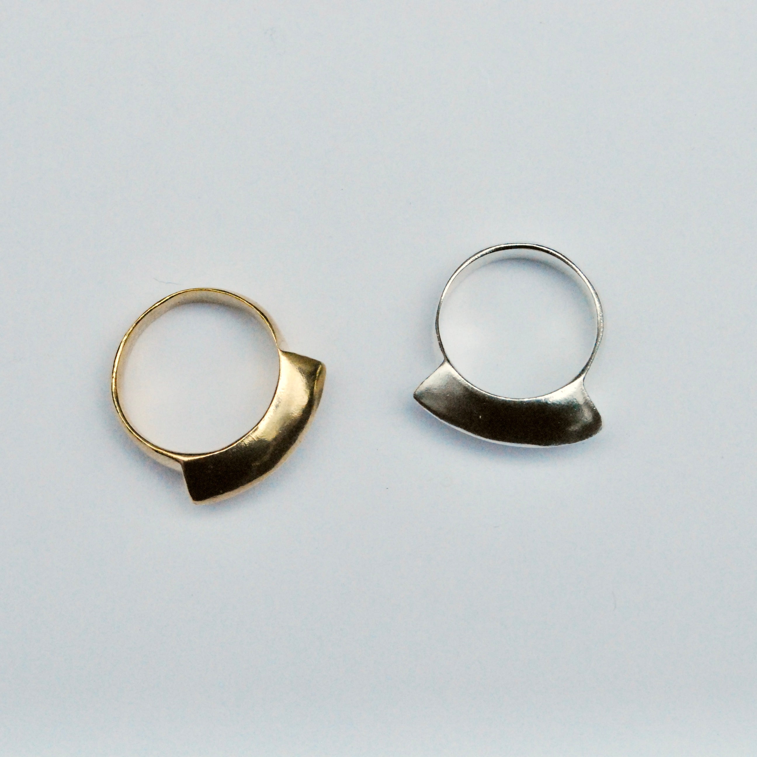 Top view of two fan shaped rings, one bronze and one silver