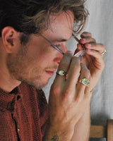 Person wearing bronze rings with mother of pearl stones