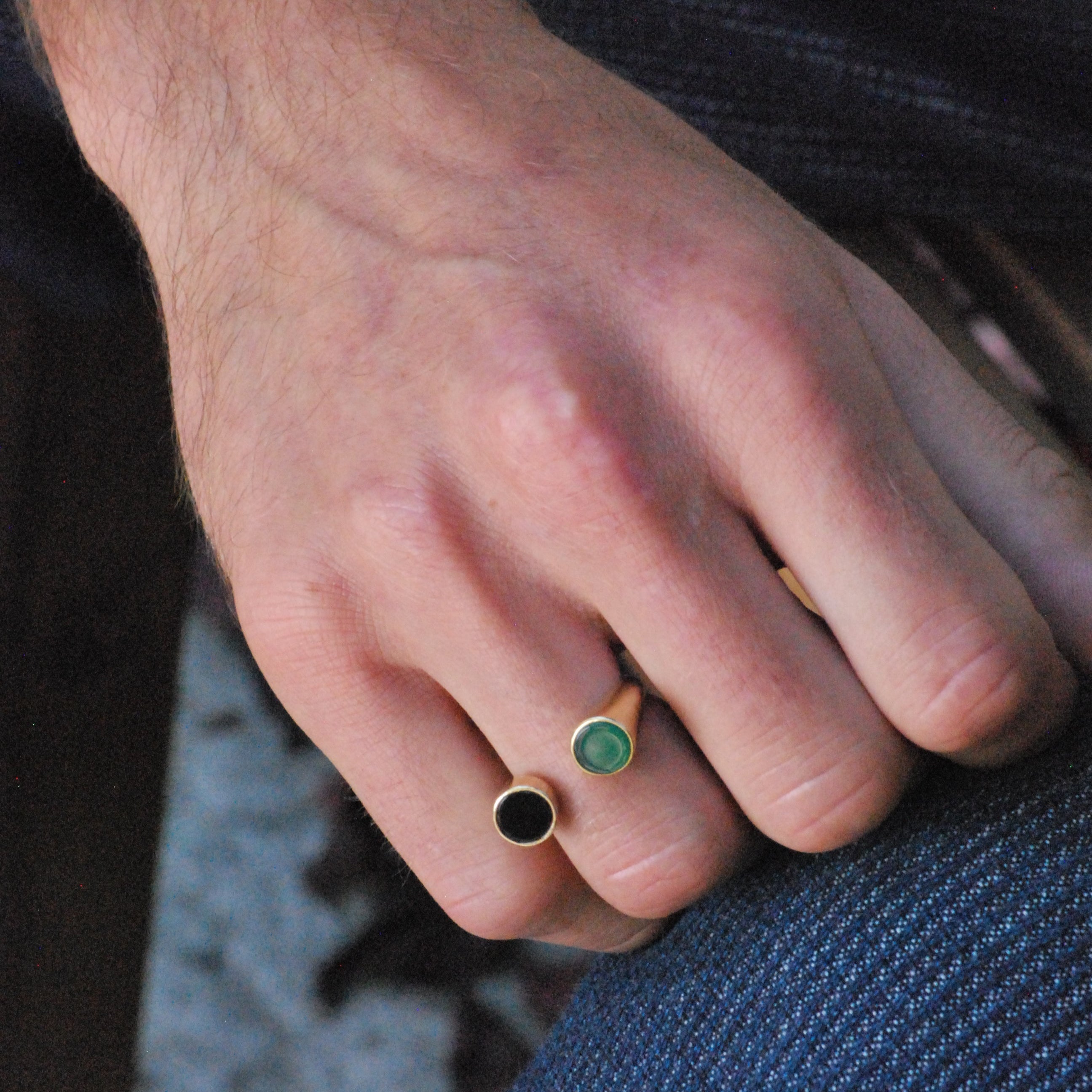 Person wearing a bronze split shank ring design with black onyx and green chrysoprase