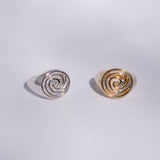 Two spiral signets in silver and bronze sit on a white background