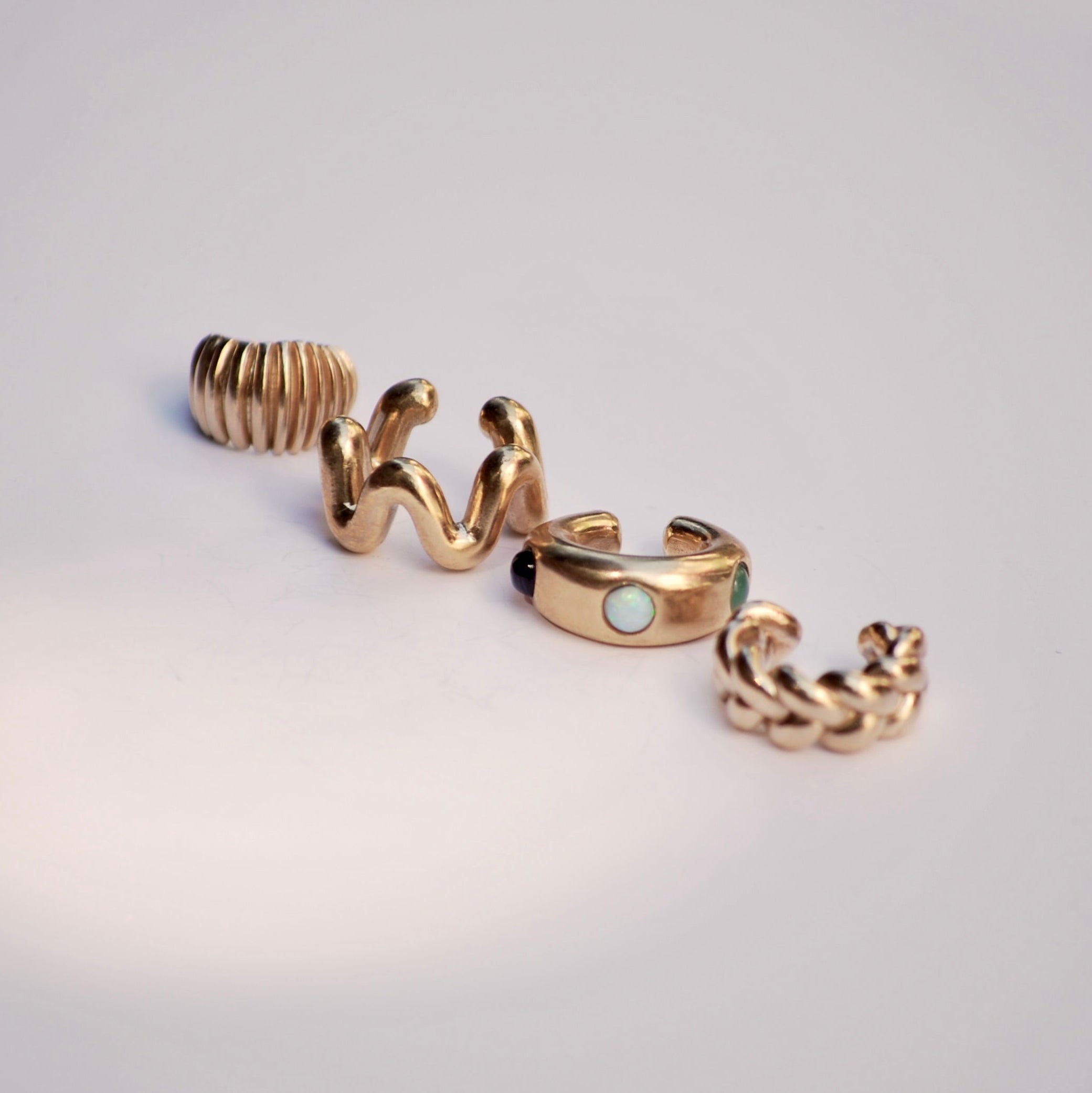 Set of gold ear cuffs on a light gray background