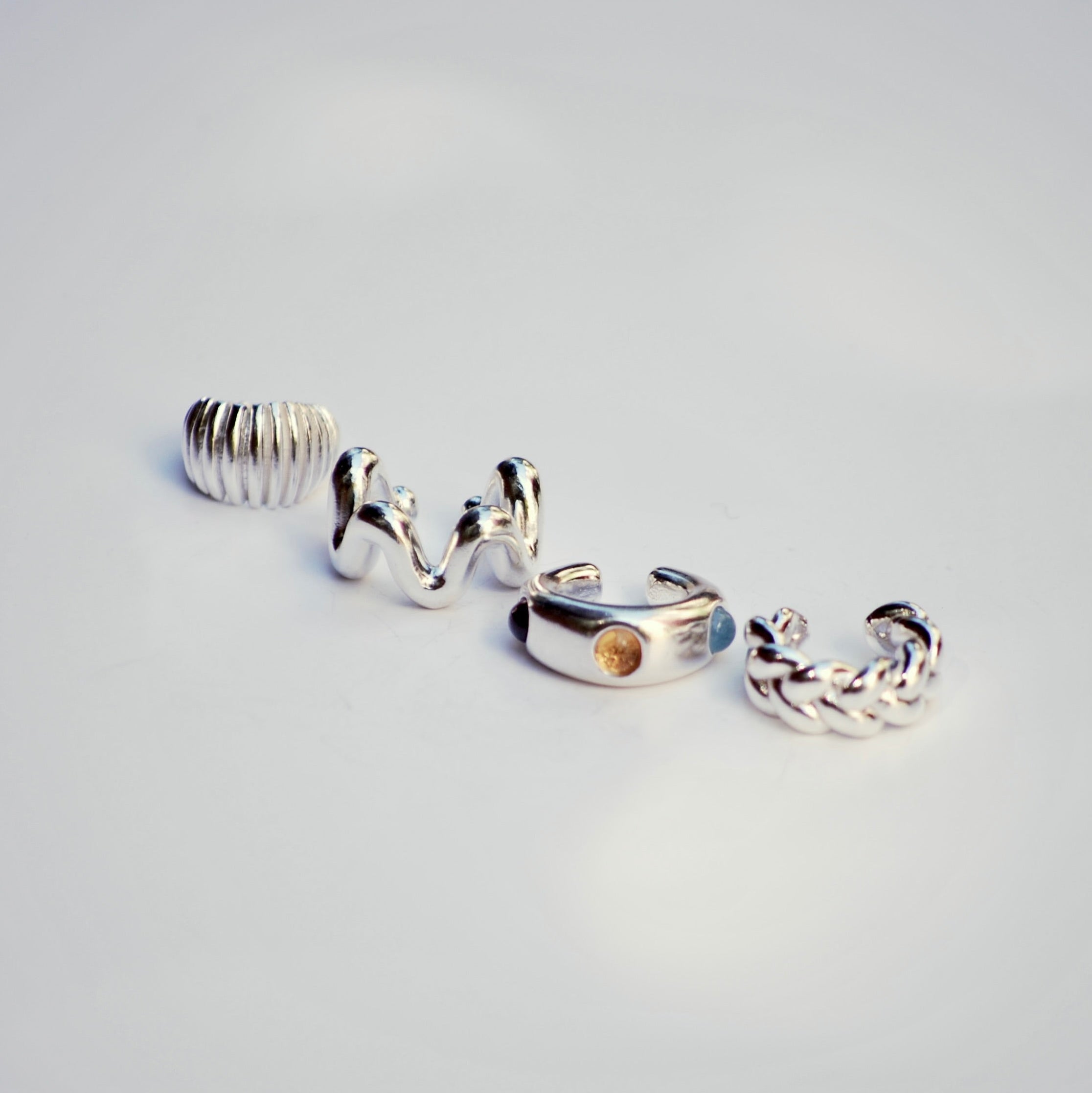 Set of silver ear cuffs on a light gray background