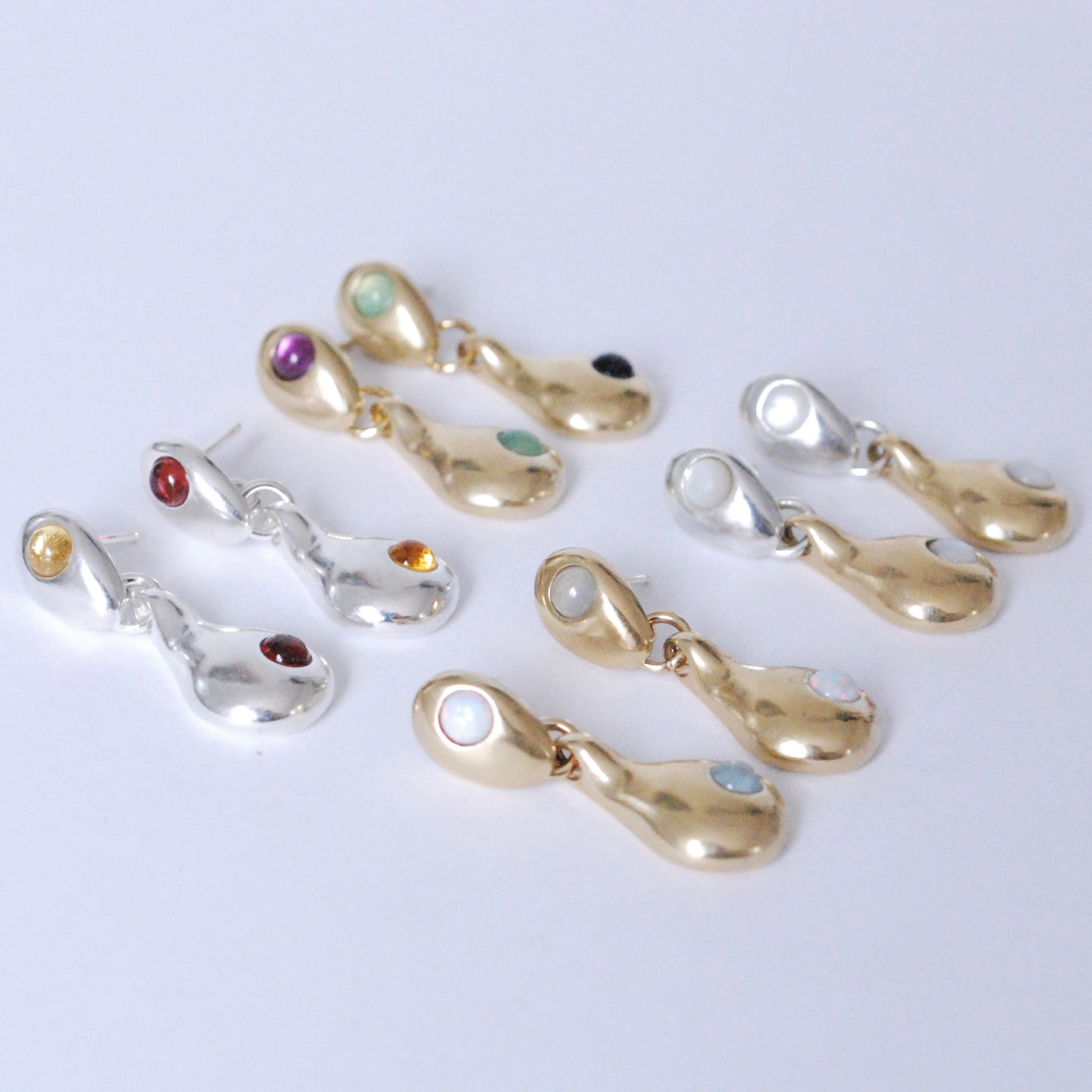 Droplet post earrings in bronze, silver, or mixed metal with different colorful stone options on a white background