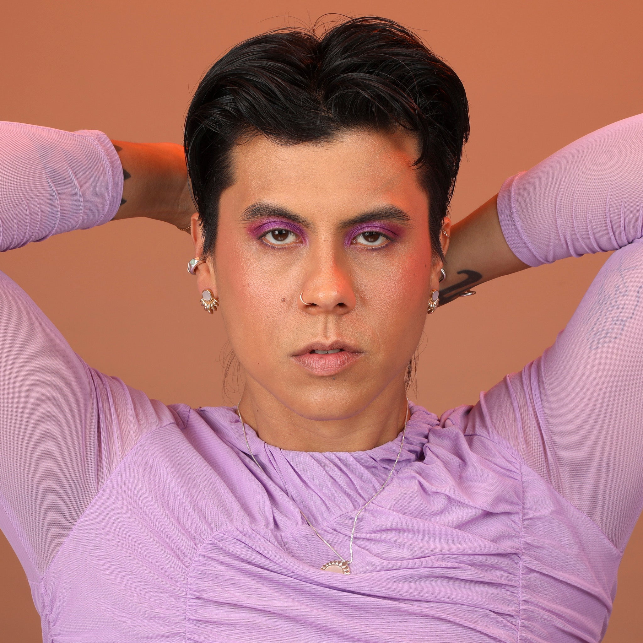 Person wearing bronze ray earrings with mother of pearl inlay