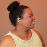 Person wearing a gold toned threader woven through two piercings