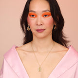 Person wearing a bronze spiral pendant necklace and spiral earrings
