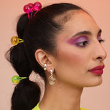 A woman wearing a spiral earring in mixed metal with a silver ear cuff with mother of pearl stones