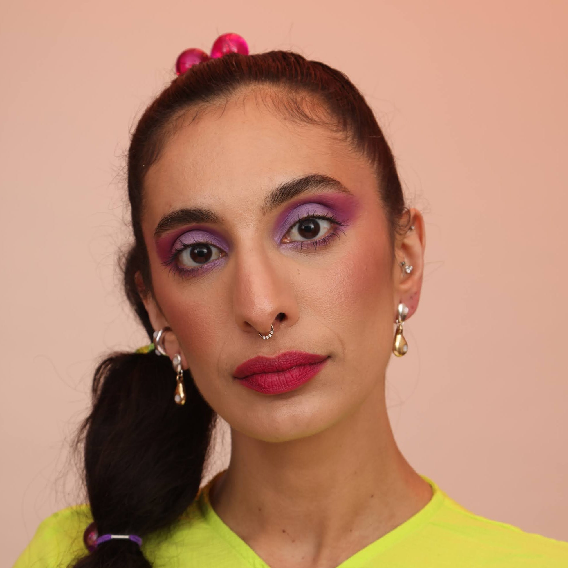 Woman wearing droplet dangle earrings in silver and bronze with mother of pearl