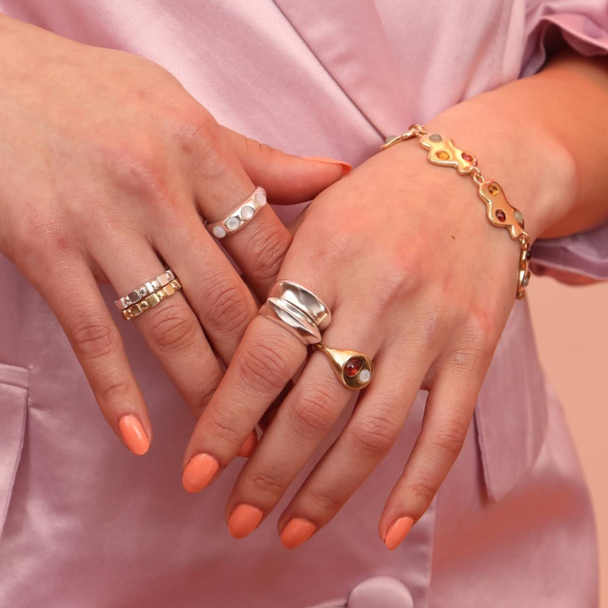 Person wearing an array of gold and silver jewelry