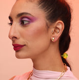 A side profile of a person wearing a teardrop-shaped earring with a color accent, matching the product description provided.