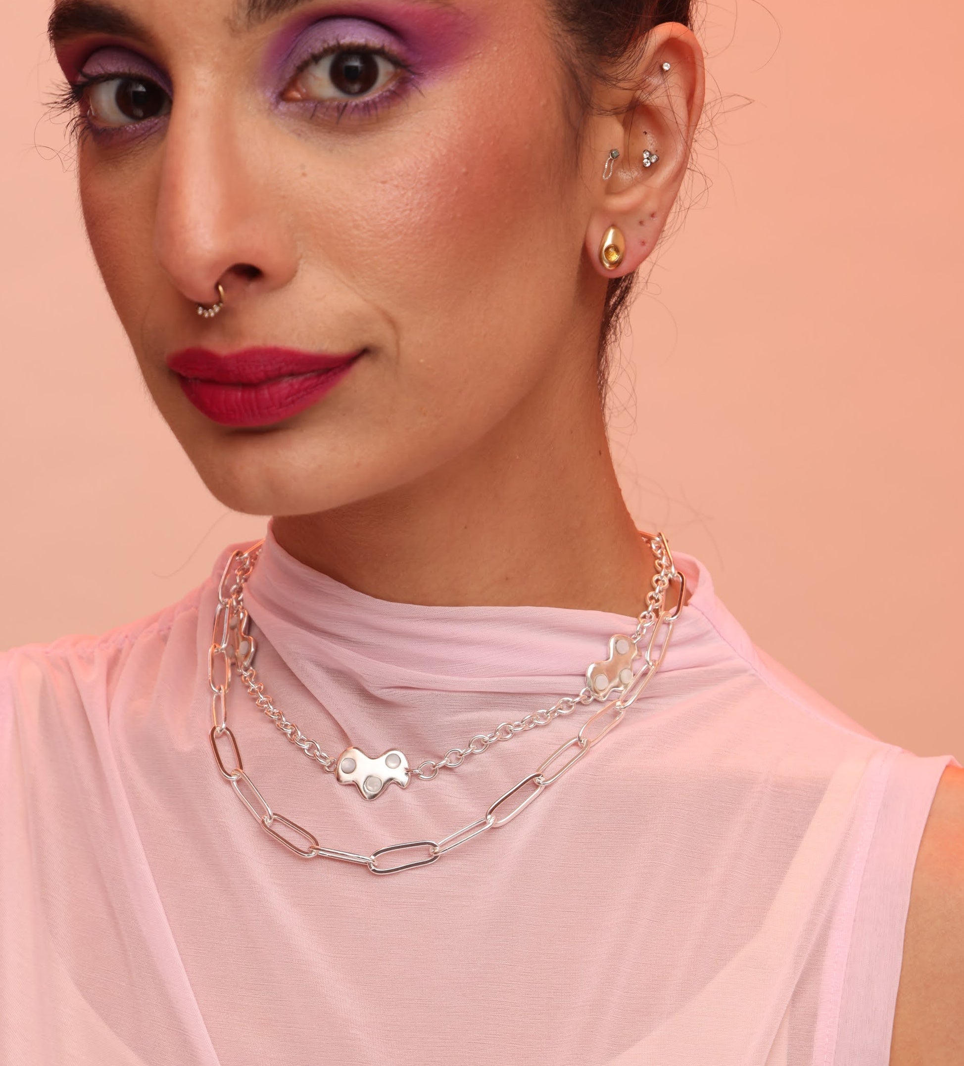 A person wearing two silver necklaces