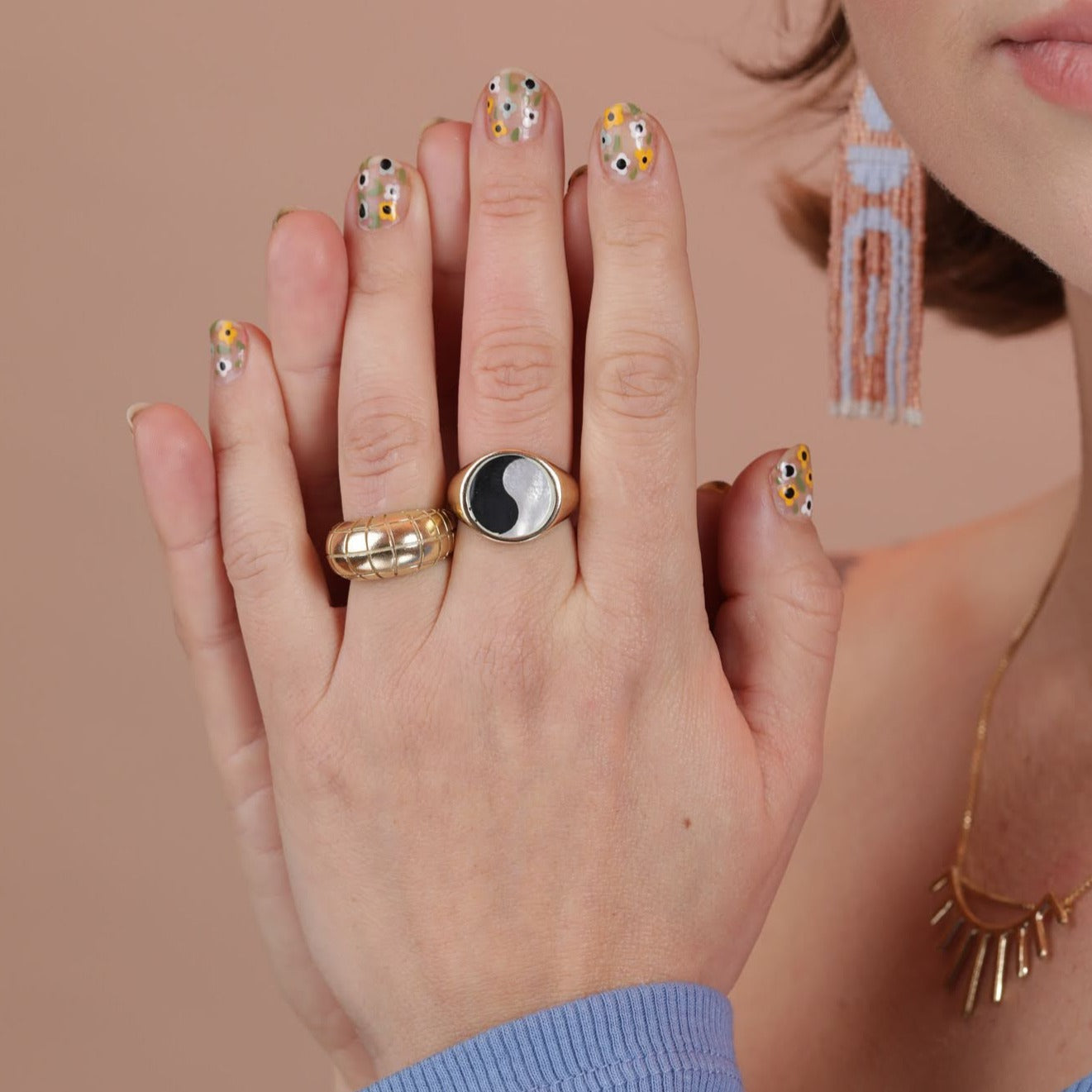 Person wearing two rings, one round signet with a ying yang pattern