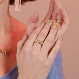 A person wearing a gold colored bronze ring shaped like a croissant