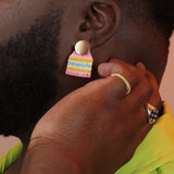 Person wearing a ridged gold colored ring on their pinky and another gold signet with a checkerboard pattern