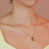 Person wearing a bronze ray shaped pendant with a ying yang pattern