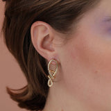 Person wearing a unique gold colored knot earring