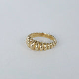 A bronze ring with a tapered shape, wider in the middle and a geometric ridged pattern all the way around it.