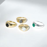 A collection of Bubble Inlay Rings with various inlay designs including black, checkered, mother-of-pearl, and green, displayed on a light background.