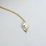 Gold colored geometric necklace on a white background