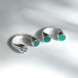 A silver ring with multiple stones inlaid in its split shank design, displayed against a grey background.