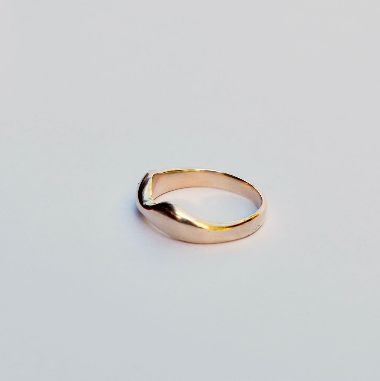 Gold ring on a light gray background