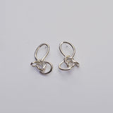 Silver knotted earrings on a light grey background