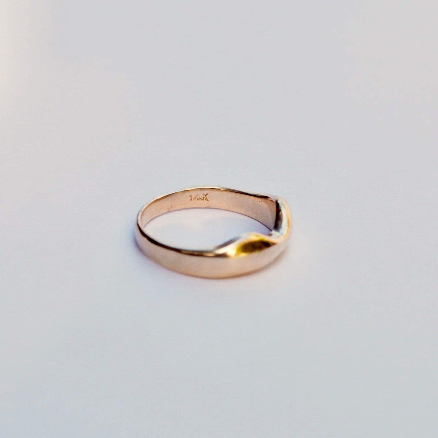 Gold ring on a light gray background