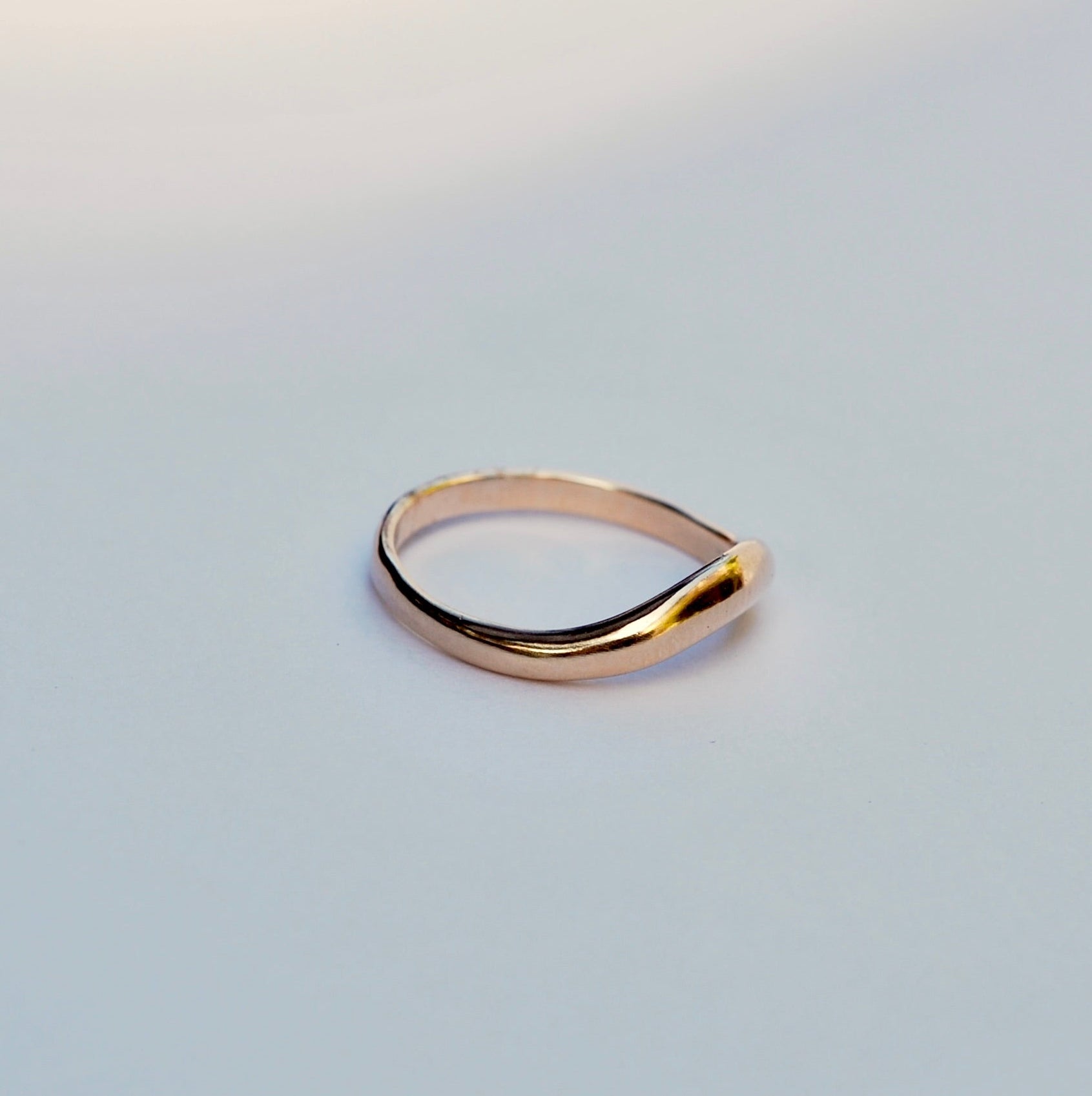 Gold ring on a light gray background