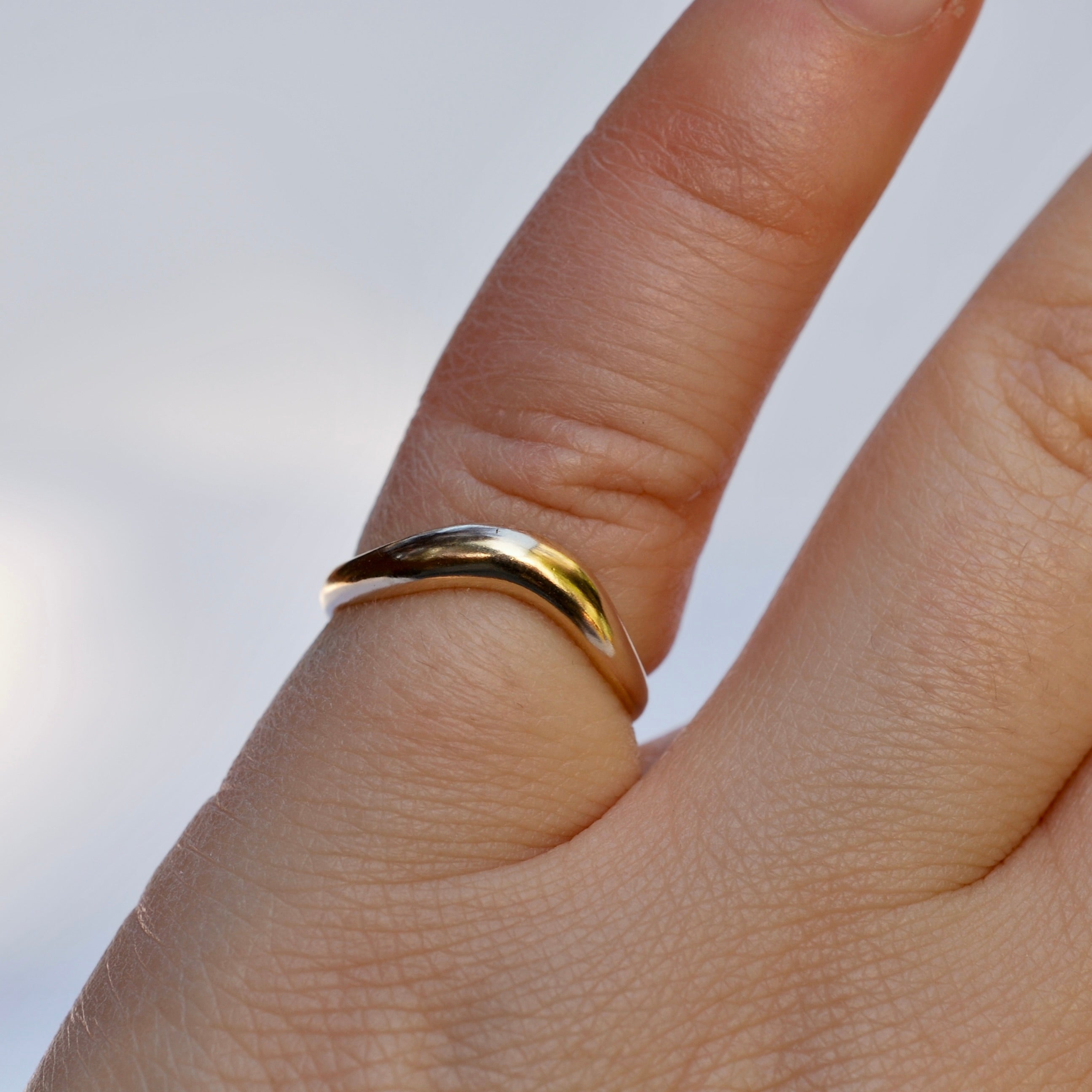 Gold ring on a finger with a blurred background