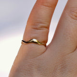 Gold ring on a finger with a plain background