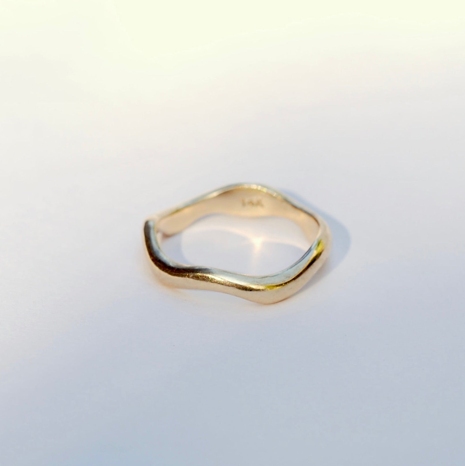 Gold ring on a light grey background