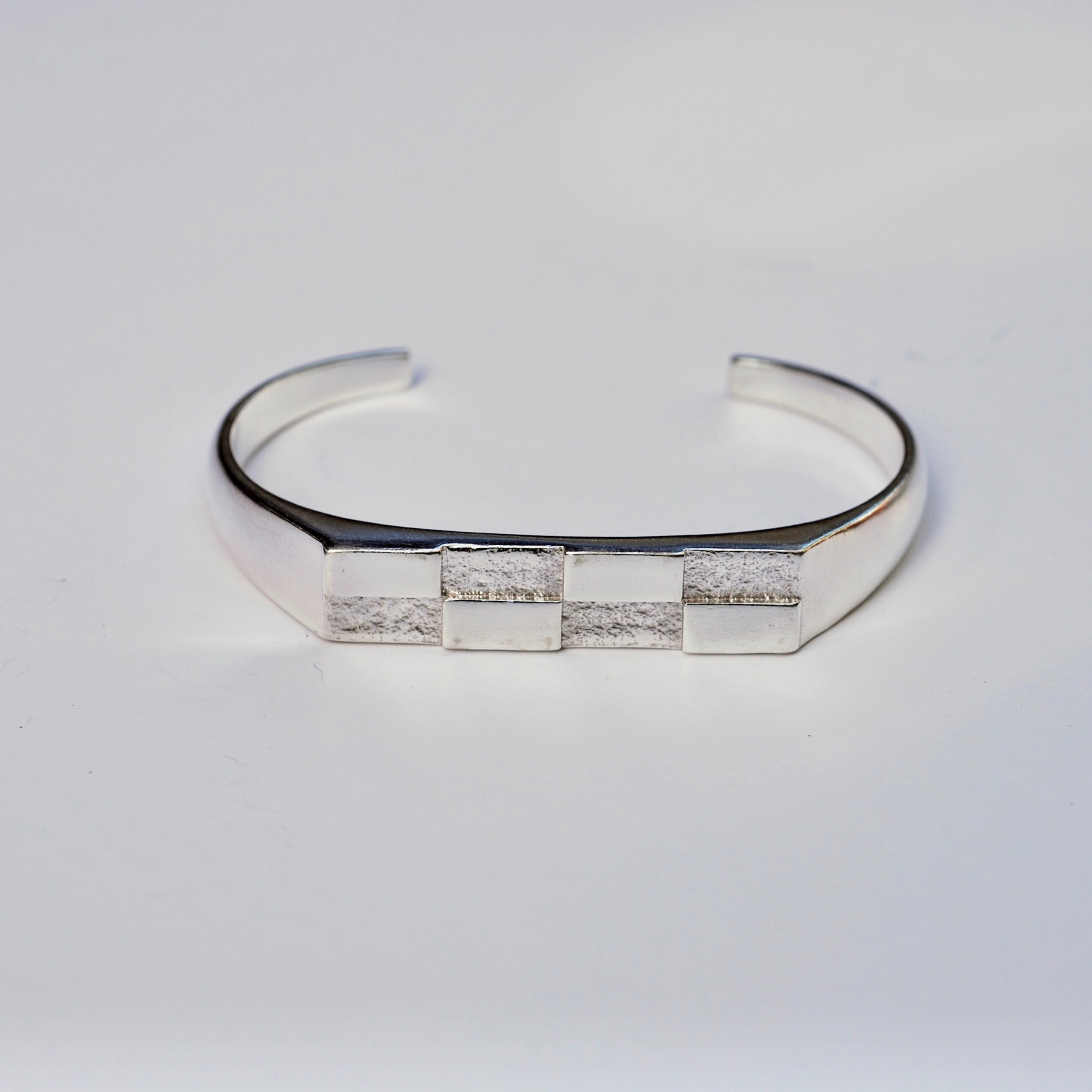 Silver cuff bracelet with a checkerboard pattern