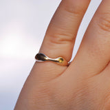 Gold ring on a finger with a plain background