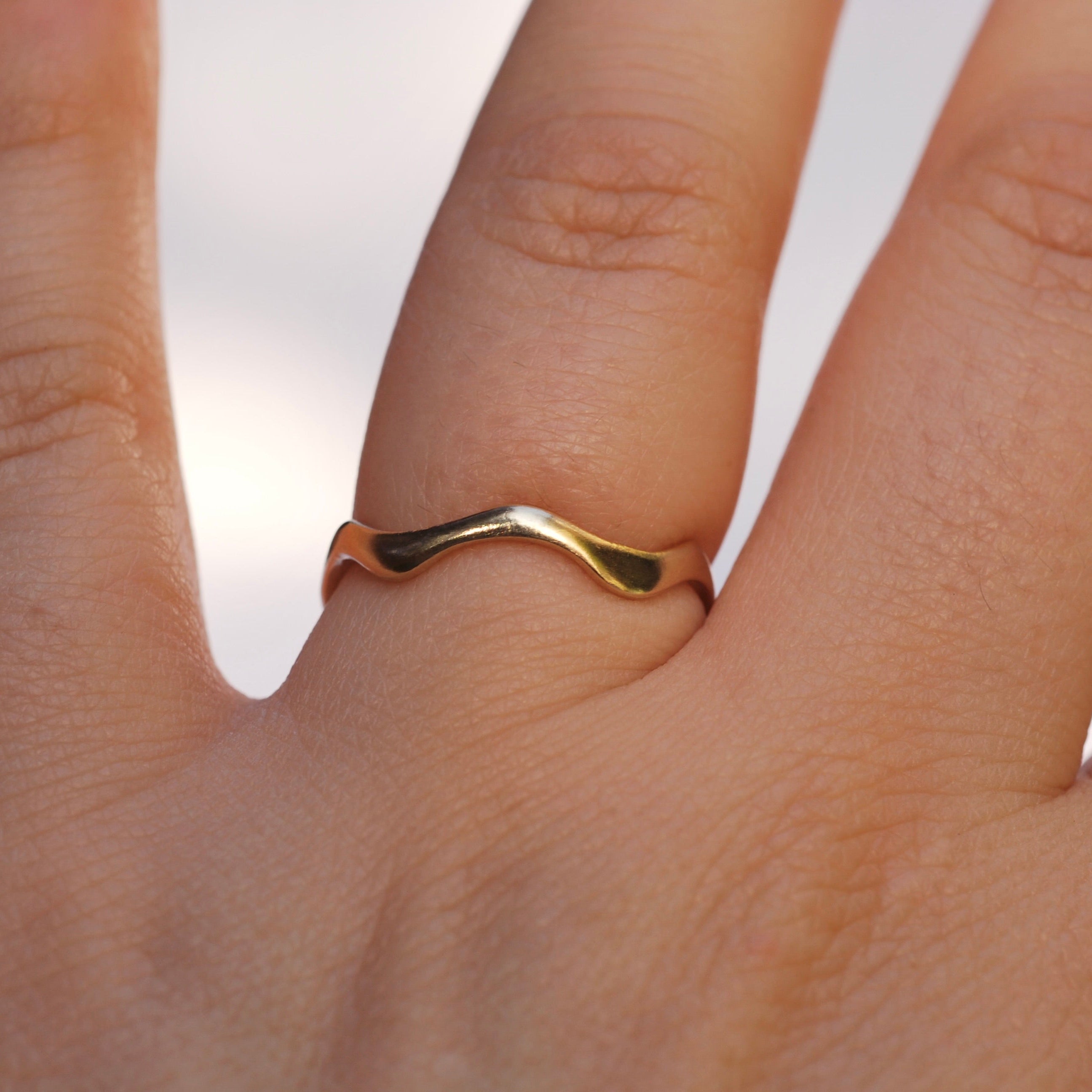 Gold ring on a finger with a blurred background