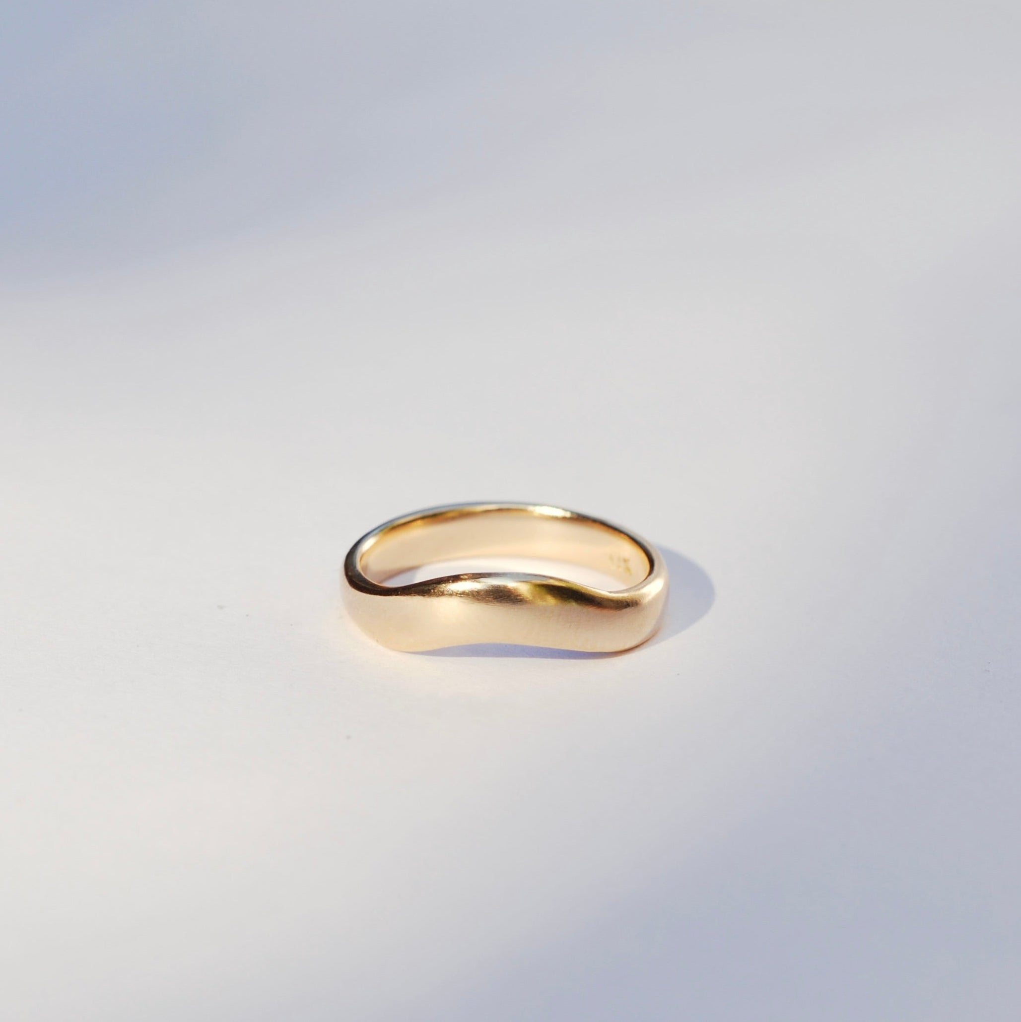 Gold ring on a light gray background