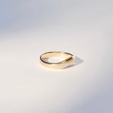 Thick Gold ring with an arch on a light gray background