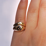 Two gold rings stacked together, one with a zircon stone and one that's an arched band above it.