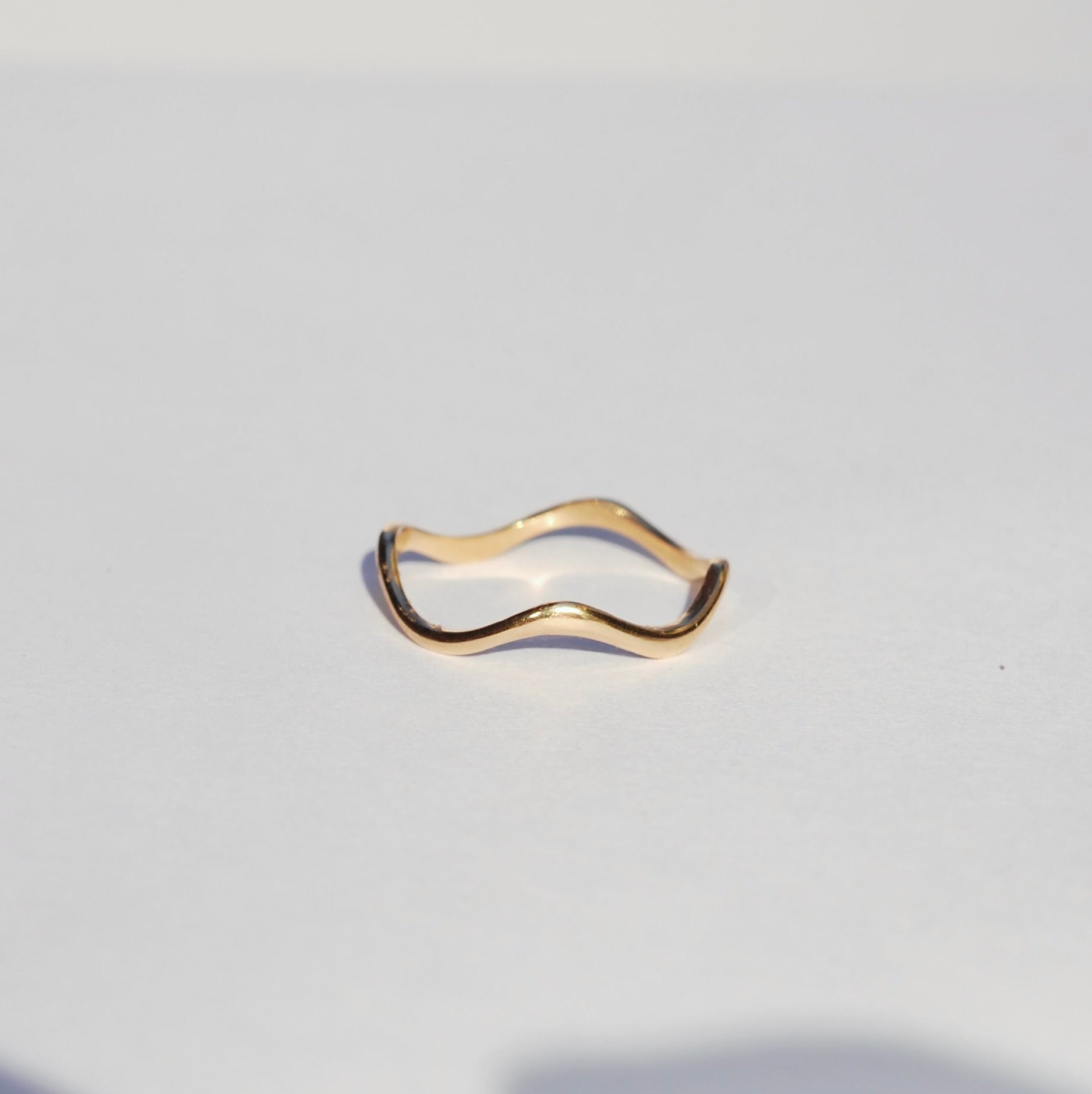 squiggly Gold ring on a light gray background