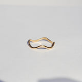 squiggly Gold ring on a light gray background