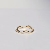 Gold ring with a unique design on a light gray background