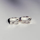 Two silver signet rings with a rectangle shape and checkerboard pattern