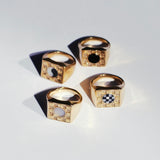 Four bronze square checkerboard signet rings with four different stone options on a white background