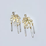 Bronze earrings with leaf-like shapes and cylindrical pearls on a light gray background