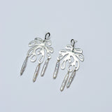 Pair of silver coral earrings with dangling pearls on a light gray background
