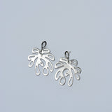 Pair of silver coral shaped earrings on a light gray background