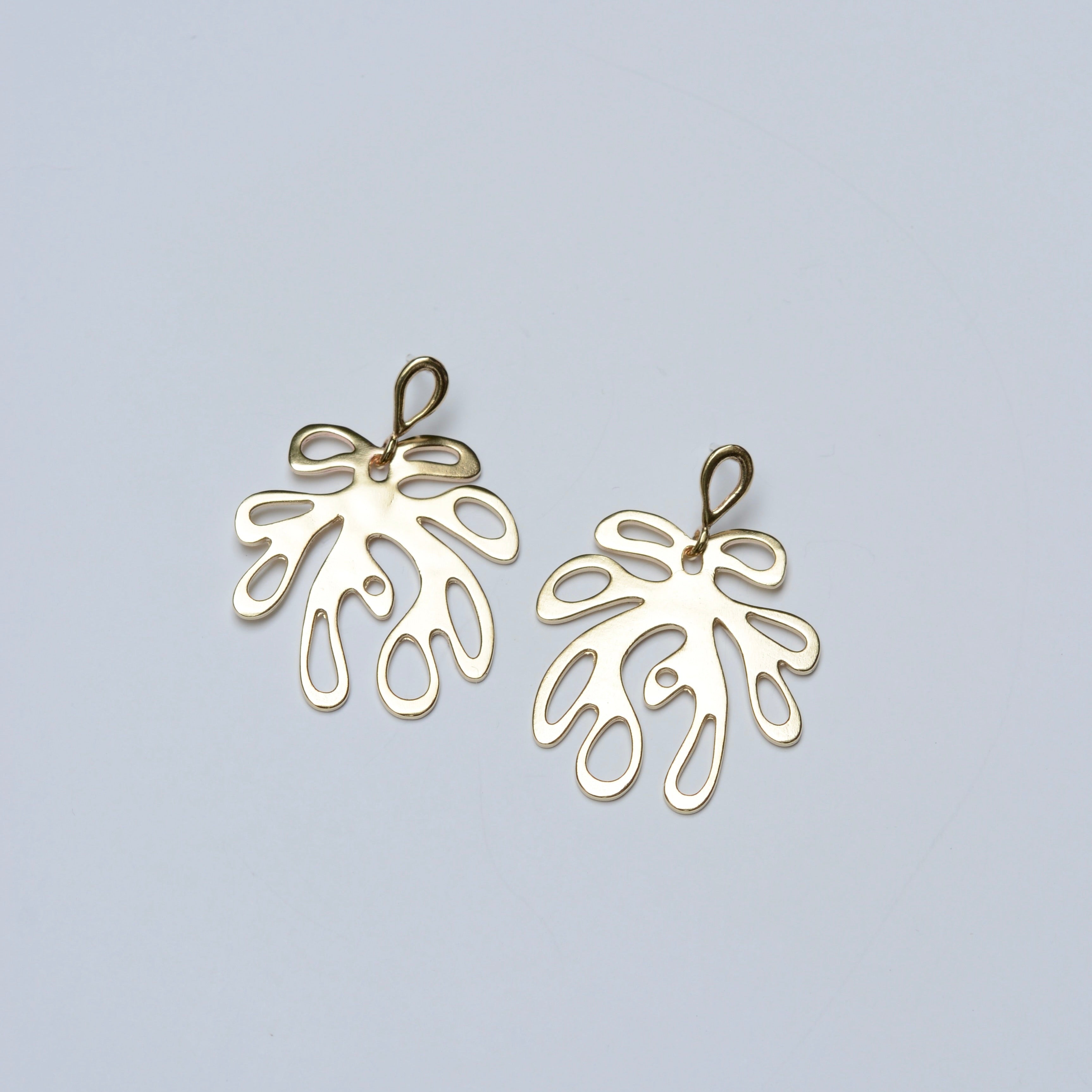 Bronze leaf-shaped earrings on a light gray background